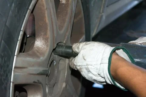 Tyre repairer fixing a wheel using an impact wrench 스톡 사진