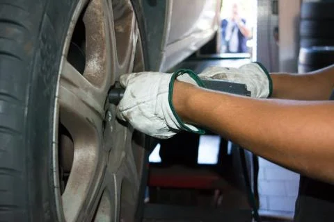 Tyre repairer fixing a wheel using an impact wrench Stock Photos