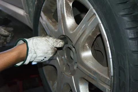 Tyre repairer fixing a wheel using an impact wrench 库存照片