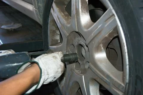 Tyre repairer fixing a wheel using an impact wrench Stock Photos