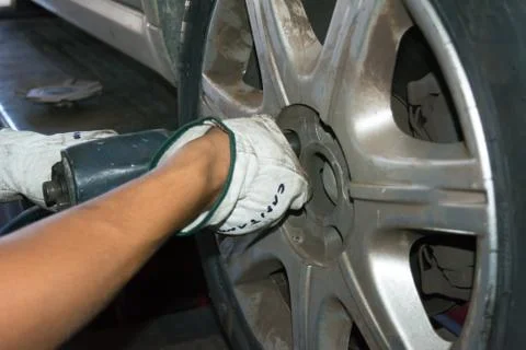 Tyre repairer fixing a wheel using an impact wrench Stock Photos