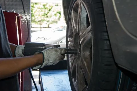 Tyre repairer fixing a wheel using an impact wrench Stock Photos
