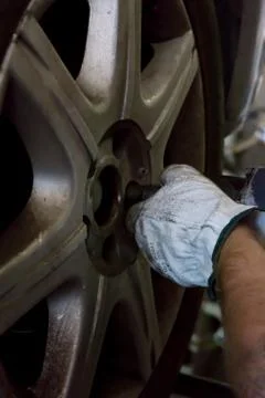 Tyre repairer fixing a wheel using an impact wrench Stockfoto's
