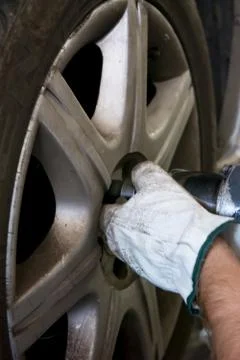 Tyre repairer fixing a wheel using an impact wrench Stockfoto's