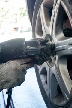 Tyre repairer fixing a wheel using an impact wrench Stock Photos