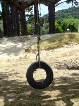 Tyre swing at the beach Stock Photos