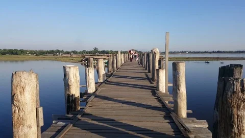 U Bein Bridge, woman carries plastic buckets on head, people, Taungthaman Lake Stock Footage
