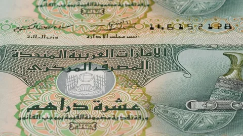 UAE 10 dirham banknotes tracking. Emirates currency. Slider shot, low angle. 4K Stock-Footage 125990187
