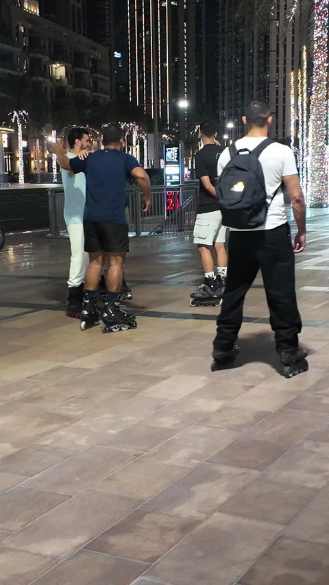 UAE - August 19, 2026 - People roller skating and parked rental e-scooters .. Stock Footage 342730838