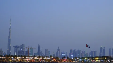 UAE flag flapping between the towers of the downtown Dubai skyline and Stock Footage 103272397
