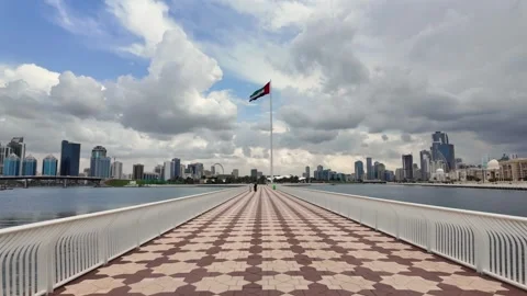 The UAE flag flutters beneath cloudy skies in Sharjah. Video stock 332684331