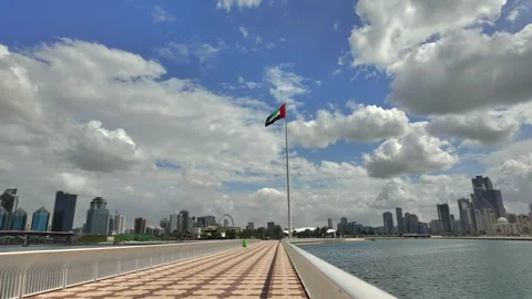 The UAE flag flutters beneath cloudy skies in Sharjah. 動画素材 332744423