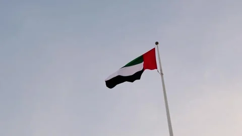 UAE flag gracefully waving against vibrant sunset sky, Stock Footage 335377486