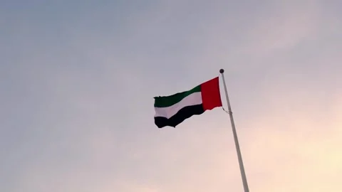 UAE flag gracefully waving against vibrant sunset sky, Stock Footage 339778322