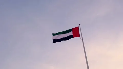 UAE flag gracefully waving against vibrant sunset sky, Stock Footage 340280724