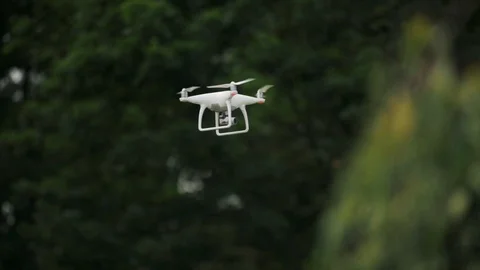 UAV Drone Quadcopter with Camera is Landing Down at a Sky and Green Background Stock Footage 101760865