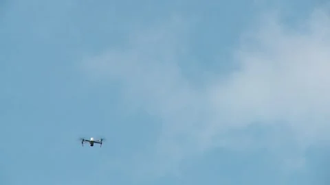 The UAV hovers in the background of a blue sky, turns around, and flies out Vidéo 336845989