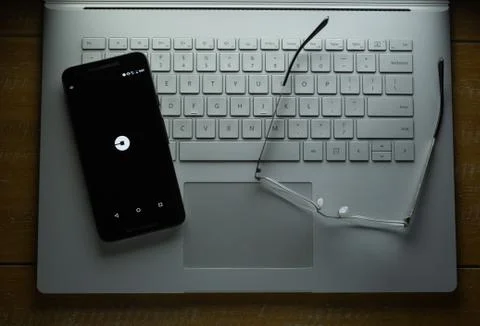 Uber app loading on Android phone in a dark room Stock Photos