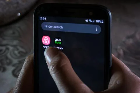 Uber Eats and airbnb apps - A girl checking applications on a smartphone Stock Photos