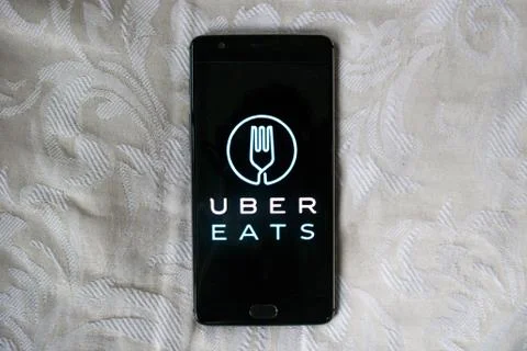 Uber Eats app on a black phone with white texture background Stock Photos