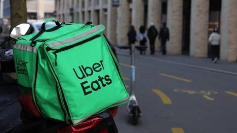 Uber Eats backpack on a bicycle in the city, food delivery service. Stock Footage 321499832