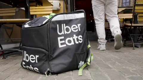 Uber Eats bag in front of restaurant as the rider walks in to pick up food Stock Footage 196882319