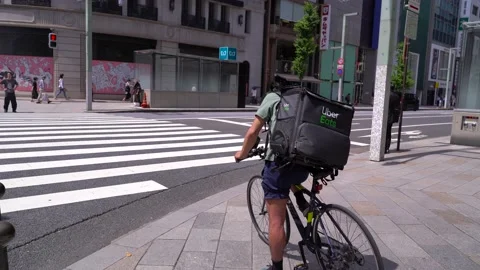 Uber Eats Bicycle Rider Wearing A Facemask Waiting At A Traffic Light In Stock Footage 130777542