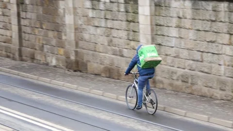 Uber Eats bike delivery driver riding through an empty street with a backpack Stock Footage 151282107