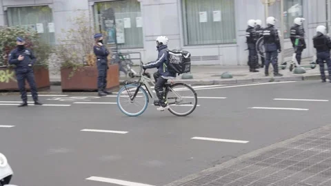 Uber eats delivery bike driver with food bag drives by police officers Stock Footage 166661182