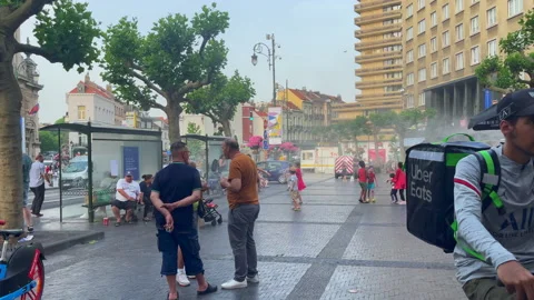 Uber eats delivery man riding his bike nearby a public square in Bruxelles Stock Footage 197573650
