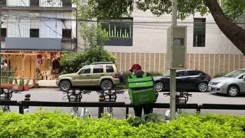 Uber Eats delivery man waits for an order in Mexico City, 4K Stock Footage 160776669