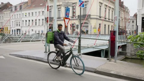 Uber Eats delivery rider cycling in the urban city center, Deliveroo Stock Footage 196849269