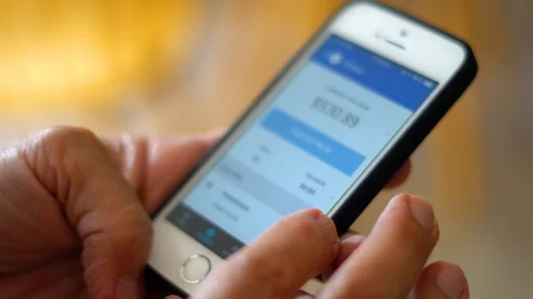 Uber Eats driver looking at his earnings in his old smartphone app in Montreal Stock Footage 94686452