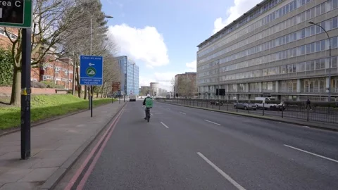 An Uber Eats fast food delivery cyclist past a Birmingham clean air zone sign Stock Footage 267377259