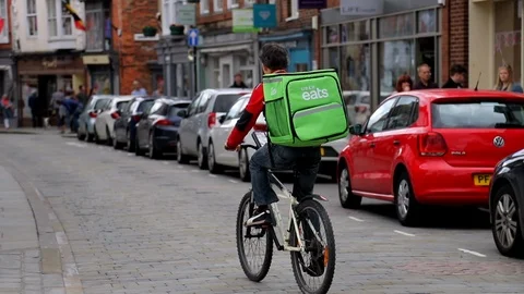 An uber eats rider delivering food in slow motion Stock Footage 92074964