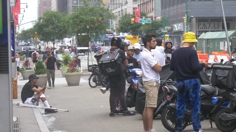 Uber Eats waiting for online orders near a bicycle lane at times square Stock Footage 246125396