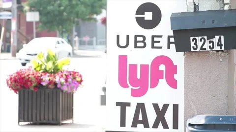 Uber lyft taxi vertical sign logos writing text next mailbox and road street Stock Footage 252043722