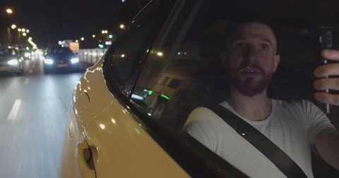 Uber passenger male is using his mobile phone for a call going through the city Stock Footage 203827181