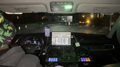 Uber Taxi Driver Operates JD Equipment While Driving Stock Footage 231728373