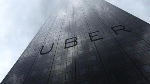 Uber Technologies Inc. logo on a skyscraper facade reflecting clouds. Editorial Ilustración de archivo