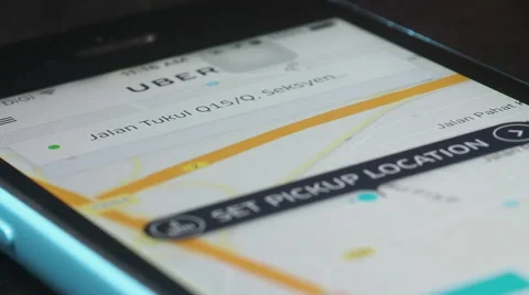 UBER user opening UBER App on his Smartphone to look for rides to Petronas Tower Stock Footage 64210428