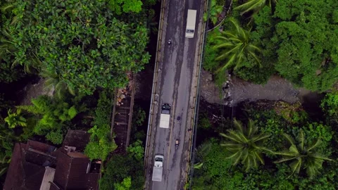 Ubud Campuhan Bridge traffic over streaming river in jungle. Perfect aerial Stock Footage 341554497