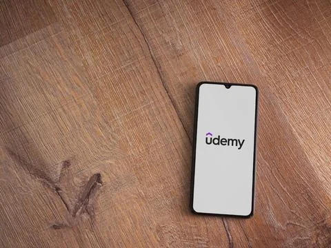 Udemy app launch screen on smartphone on wooden background Stock Photos