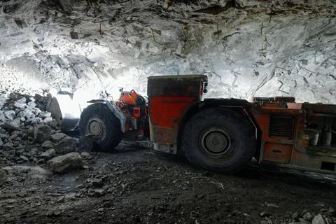 Uderground loading machine Picks up stones into the bucket from the face. Stock Photos