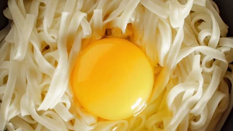 Udon noodles with raw egg close-up, rotating Video stock 243989690