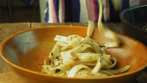 Udon with vegetables is transferred from the pan to a plate Stock Footage 203907017