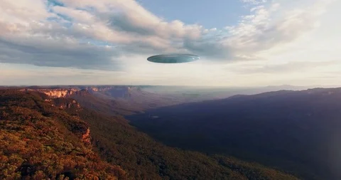 UFO descends in between mountains in valley Stock Footage 88090337