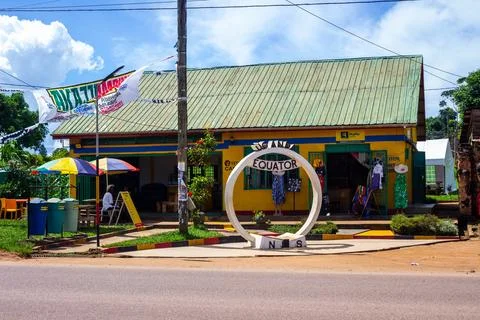 Uganda Equator statue to indicate th equator line in front of local bar Stock Photos