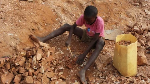 A Ugandan boy breaking rocks into small slabs in a quarry. 스톡 동영상 96462973