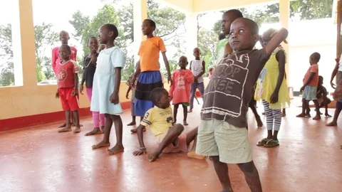 A Ugandan teacher doing physical execrices and games with children. Stock Footage 104265263